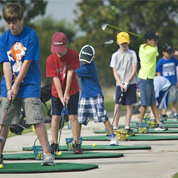 A line of children play golf during the annual Junior Golf Clinic on the Oaks Golf Course at Randolph Air Force Base, Joint Base San Antonio, Texas, June 13, 2012. The clinic is a recreational activity to teach children of U.S. Service members or Department of Defense civilians the basics of golf and course etiquette. (U.S. Air Force photo by Benjamin Faske/Released)